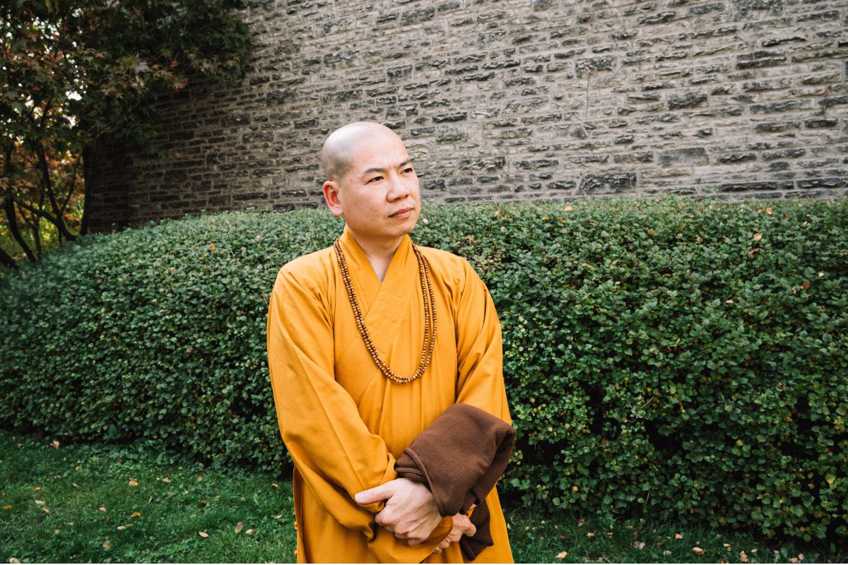 The Venerable Jianzong, abbot of Ching Kwok Buddhist Temple, stands outside Emmanuel College where his temple has endowed a scholarship in his master's name.