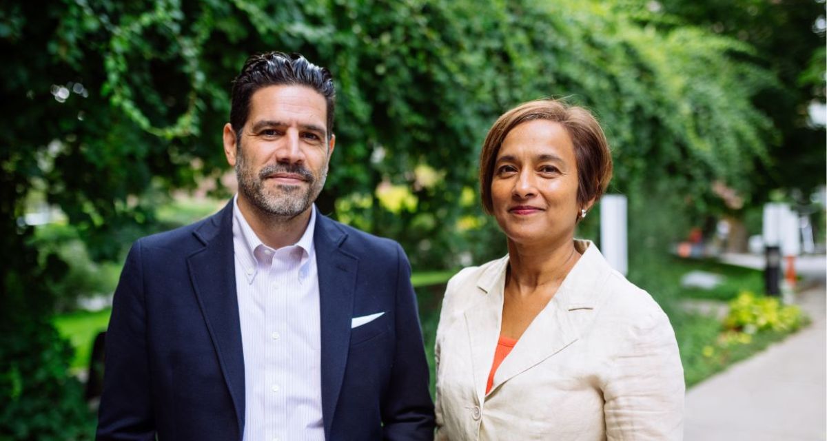 Principal Alex Hernandez and Registrar Yvette Ali stand smiling, with a lush green garden backdrop in the camera. (Photo by Will Dang)