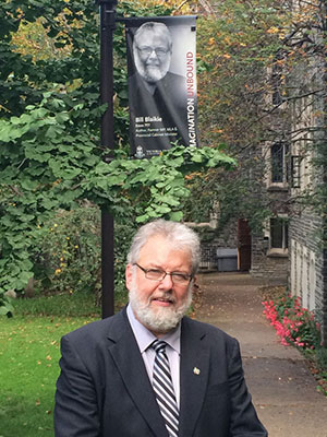 Bill Blakie standing on Emmanuel College campus. 