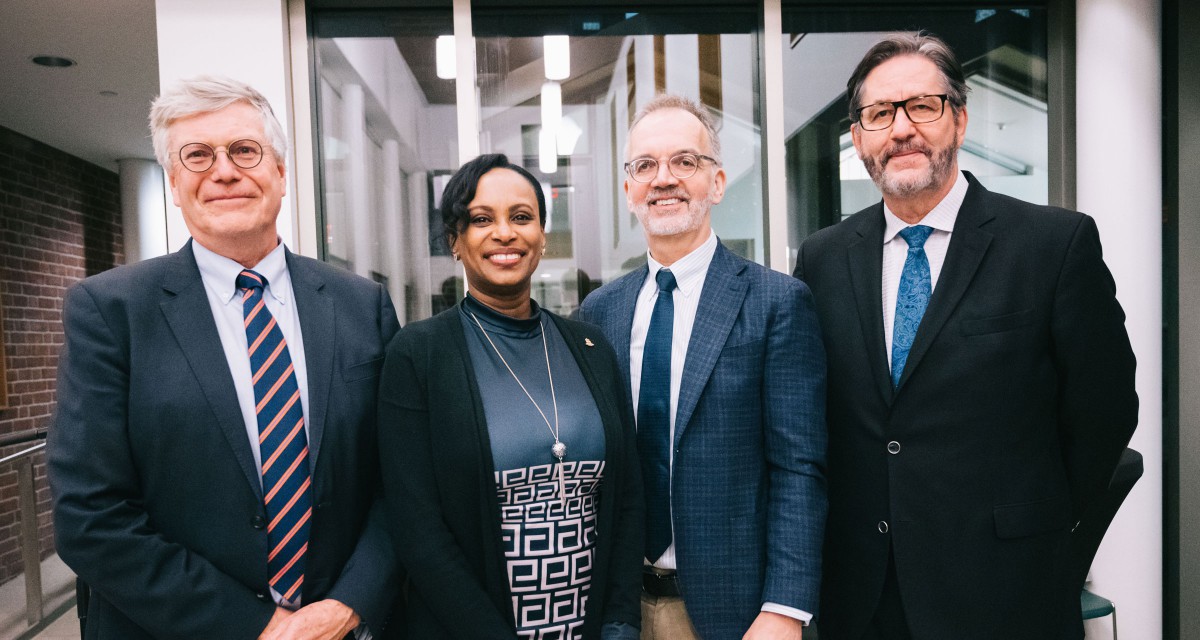 A group photo from a University of Toronto signing ceremony. From left to right: Nicholas Terpstra, Provost and Vice-Chancellor of Trinity College; Rhonda N. McEwen, President and Vice-Chancellor of Victoria University; Dr. Trevor Young, Vice President and Provost at the University of Toronto; and Dr. David Sylvester, President and Vice-Chancellor of the University of St. Michael's College. They stand together, smiling.