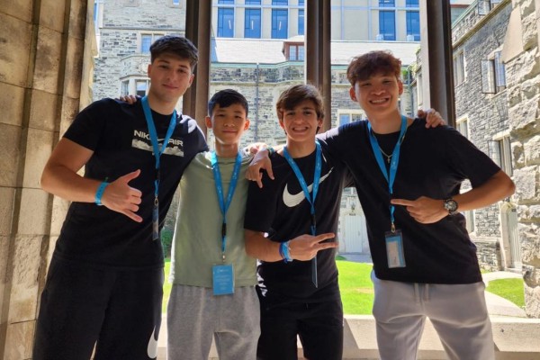 Four boys pose for the camera while standing in a building on Victoria University campus.